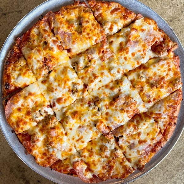 Jimmy's Pizza's freshly baked, square-cut pizza with melted cheese and meat toppings on a metal pan.