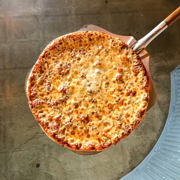 A freshly baked cheese pizza from Jimmy's Pizza on a metal peel, ready to serve.
