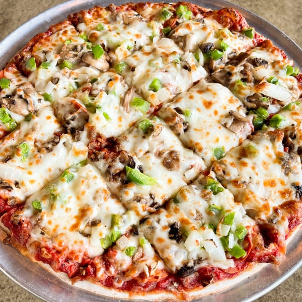 A freshly baked Jimmy's Pizza with melted cheese, green peppers, onions, and mushrooms on a metal pan.